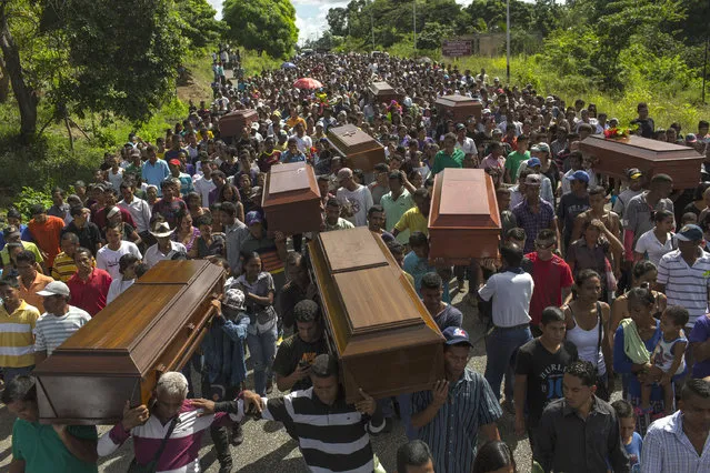 In this November 13, 2016 photo, villagers carry the remains of nine slain men from a fishing family to the cemetery in Cariaco, Sucre state, Venezuela. Five law enforcement officers were charged with storming the village and killing these men, who were widely thought to have belonged to a gang. (Photo by Rodrigo Abd/AP Photo)