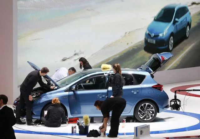 Employees prepare a new Toyota Auris Hybrid car ahead of the 85th International Motor Show in Geneva, March 2, 2015.            REUTERS/Arnd Wiegmann (SWITZERLAND  - Tags: TRANSPORT BUSINESS)  