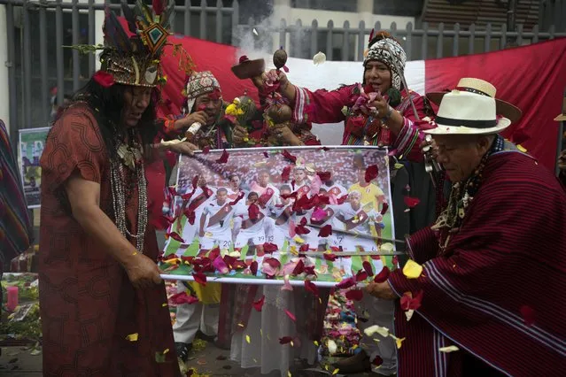 Peruvian shamans hold a poster of Peru's national soccer team while performing a good luck ritual outside the National Stadium in Lima, Peru, Monday, September 11, 2023. Peru will face Brazil in a World Cup 2026 qualifying soccer match in Lima on Sept. 12. (Photo by Martin Mejia/AP Photo)