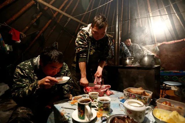 Reindeer herders cook and have a meal inside a tent in the tundra area in Nenets Autonomous District, Russia, November 27, 2016. (Photo by Sergei Karpukhin/Reuters)
