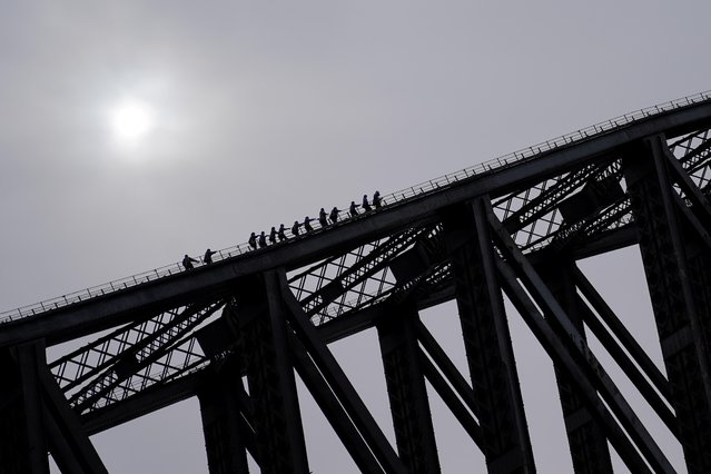 People climb the Sydney Harbour Bridge on a guided tour as eastern Australia experiences a winter cold front, in Sydney, Australia, June 10, 2021. (Photo by Loren Elliott/Reuters)