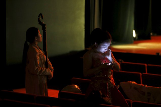 A member of the Shanxi Folk Dance and Music Troupe checks her mobile during a rehearsal before a show at the Orient Museum in Lisbon February 1, 2016. (Photo by Rafael Marchante/Reuters)