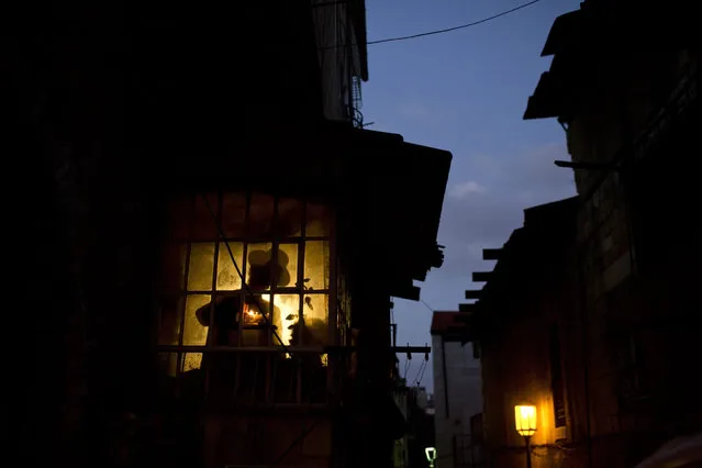 An Ultra-Orthodox Jew lights a Hanukkah candle with his son in his house during the Jewish holiday of Hanukkah in the Mea Shearim neighbourhood of Jerusalem, Israel, 28 December 2016. Hanukkah, also known as the “Festival of Lights”, is one of the most important Jewish holidays and is celebrated by Jews worldwide. (Photo by Abir Sultan/EPA)