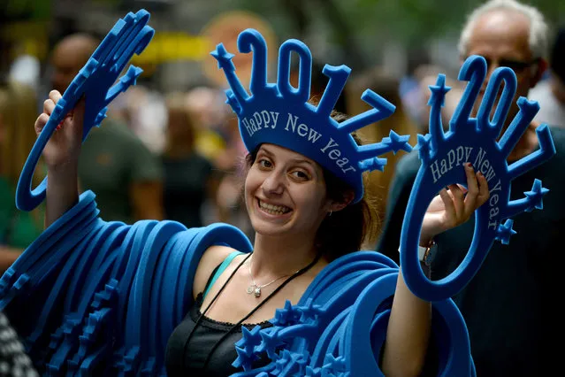 A woman sells “Happy New Year 2017” headwear on a shopping street in Sydney on December 30, 2016. Counter-terrorism police have arrested a man in Sydney for allegedly making threats against New Year's Eve celebrations in an online blog, authorities said on December 30. (Photo by Peter Parks/AFP Photo)