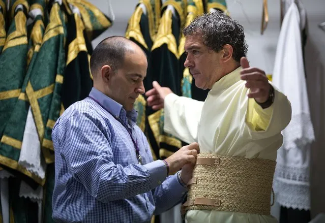 Antonio Banderas (R) is helped to dress as he attends the Maria Santisima de Lagrimas y Favores procession at San Juan Bautista church during Holy Week celebrations on March 29, 2015 in Malaga, Spain. (Photo by Gonzalo Arroyo Moreno/Getty Images)