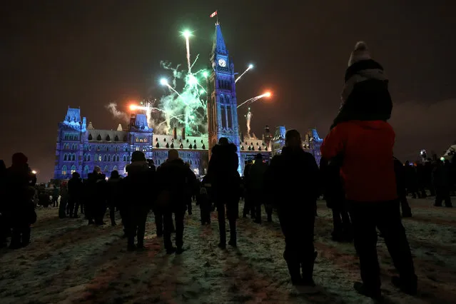 People watch fireworks during the annual Christmas Lights Across Canada ceremony on Parliament Hill in Ottawa, Ontario, Canada, December 5, 2018. (Photo by Chris Wattie/Reuters)