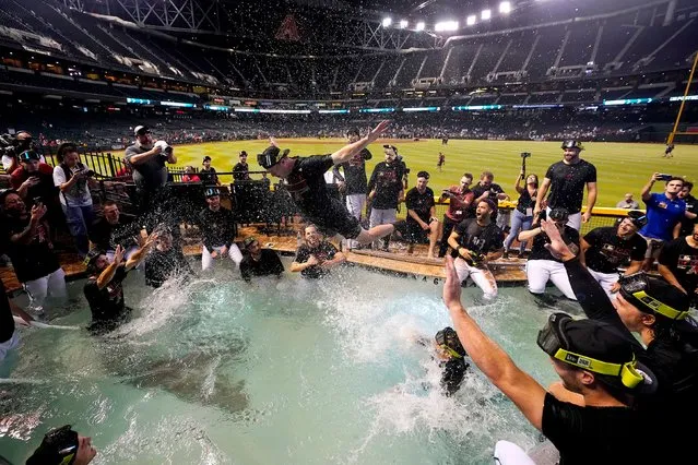 The Arizona Diamondbacks players celebrate in the Chase Field pool after clinching a Wild Card spot in the MLB playoffs after a baseball game against the Houston Astros, Saturday, September 30, 2023, in Phoenix. The Astros won 1-0. (Photo by Ross D. Franklin/AP Photo)