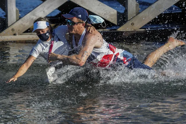 Great Britain's Hanna Mills is thrown at the water after winning the 470 women's gold medal at the Enoshima harbour during the 2020 Summer Olympics, Wednesday, August 4, 2021, in Fujisawa, Japan. (Photo by Bernat Armangue/AP Photo)