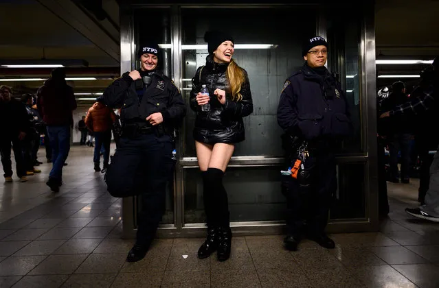 A participant in the 18th Annual “No Pants Subway Ride” laughs with a police officers on January 13, 2019 in New York. The “No Pants Subway Ride” is an annual event started in 2002 by Improv Everywhere in New York, the goal of which is for subway riders to dress in normal winter clothes without pants while keeping a straight face. (Photo by Johannes Eisele/AFP Photo)