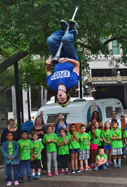 XPogo athlete Ryan O'Malley flips in the air during his extreme pogo demonstration in Hemming Park, in Jacksonville, Fla., Thursday, April 16, 2015. (Photo by Bob Mack/The Florida Times-Union via AP Photo)