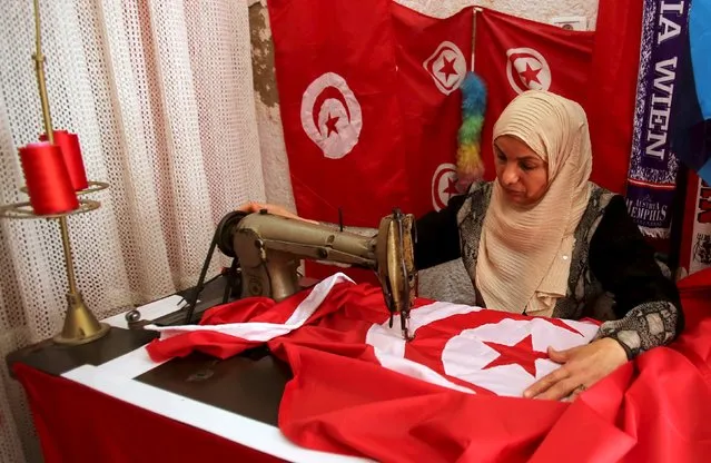 A worker sews Tunisian national flags in a workshop in Tunis April 17, 2015. Picture taken April 17, 2015. (Photo by Zoubeir Souissi/Reuters)
