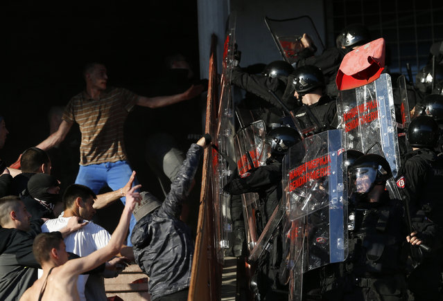 Red Star soccer fans clash with police during a Serbian National soccer league derby match between Red Star and Partizan, in Belgrade, Serbia, Saturday, April 25, 2015. (Photo by Darko Vojinovic/AP Photo)