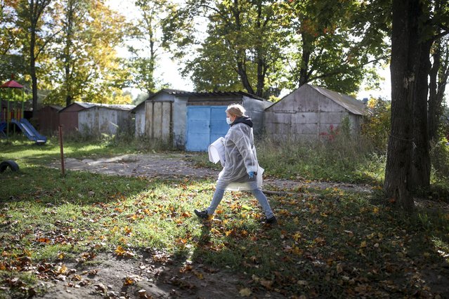 A member of an election commission carry election ballots to a mobile polling station during the Parliamentary elections in Sharapovo village, Moscow region, Russia, Saturday, September 18, 2021. The Communist Party and independent observers have reported an array of alleged violations in the voting that is widely expected to keep the dominant United Russia party's majority in parliament. (Photo by Evgeny Feldman/Meduza via AP Photo)