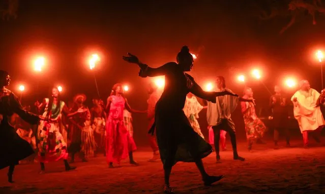 Ethnic groups in the village of Mbourokh near the city of Mbour are viewed dancing in a large circle around the tourists with torches in their hands in Mbour, Senegal on January 05, 2024. In Senegal, the “surprise” dinner organized with the dance and music of ethnic groups among baobab trees offers colorful slices of Senegalese culture and gives foreign tourists pleasant moments. Ethnic groups in the village of Mbourokh, about 100 kilometers from the capital Dakar, present their unique dances and rituals to visitors. (Photo by Cem Ozdel/Anadolu via Getty Images)