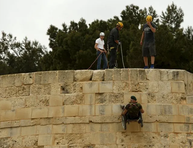 British former police officer Swasie Turner abseils for charity in a wheelchair down the fortification bastions of Valletta, Malta, April 27, 2015. (Photo by Darrin Zammit Lupi/Reuters)