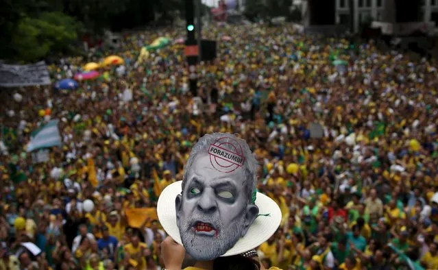 A demonstrator wears a mask depicting Brazil's former President Luiz Inacio Lula da Silva during a protest against Brazil's President Dilma Rousseff, part of nationwide protests calling for her impeachment, in Sao Paulo, Brazil, March 13, 2016. (Photo by Nacho Doce/Reuters)