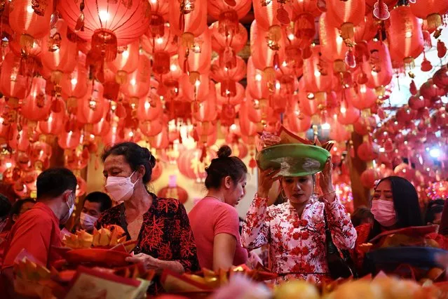 People give offerings and pray at Wat Mangkon temple in Chinatown in Bangkok on February 10, 2024, on the first day of the Lunar New Year of the Dragon. (Photo by Lillian Suwanrumpha/AFP Photo)