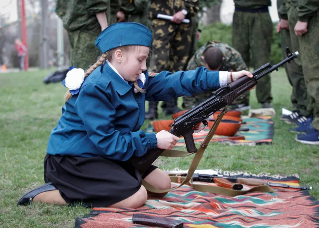 A school student assembles Kalashnikov rifle during a military patriotic game “I am Patriot” in the rebel-held settlement of Makiivka (Makeyevka) outside Donetsk, Ukraine on April 13, 2019. (Photo by Alexander Ermochenko/Reuters)