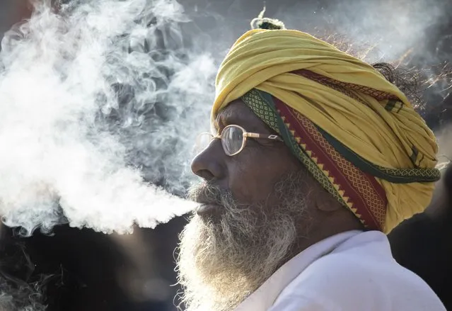 A Sadhu, or Hindu holy person, smokes marijuana from a clay pipe on the Eve of the Maha Shivaratri festival at the Pashupati Temple in Kathmandu, Nepal, 07 March 2024. Mahashivratri is considered one of the most auspicious festivals for the Hindu community. Hundreds of Sadhus and pilgrims from across the country and neighboring India gather to celebrate the birthday of lord Shiva, the god of creation and destruction, by offering special prayers and fasting. Selling Marijuana is an illegal in Nepal, however the administration overlooks selling and smoking Marijuana for this day. (Photo by Narendra Shrestha/EPA)