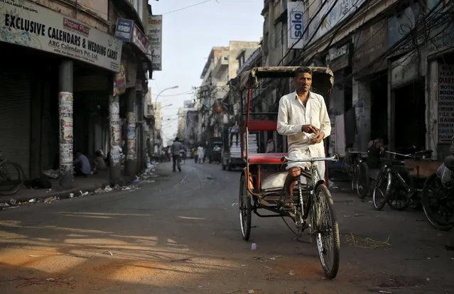 A rickshaw puller waits for customers on a street in the old quarters of Delhi, India, March 29, 2016. (Photo by Anindito Mukherjee/Reuters)
