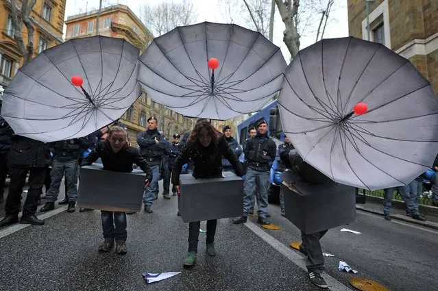 People hold fake satellite dish to protest against the installation of MUOS, an array of communication satellites developed by the US Department of Defense on the sidelines of the visit of US President Barack Obama in Rome on March 27, 2014 near the US Embassy. (Photo by Tiziana Fabi/AFP Photo)