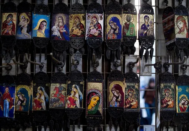 In this Saturday, April 16, 2016 photo, Christian icons depicting the Virgin Mary and Jesus Christ are displayed in a shop outside the historic 7th century Umayyad Mosque, that was built on the site of a Christian basilica, in Damascus, Syria. The mosque is and one of the oldest and largest mosques in the world and an adjacent mausoleum contains the tomb of medieval Muslim Sultan Saladin. (Photo by Hassan Ammar/AP Photo)