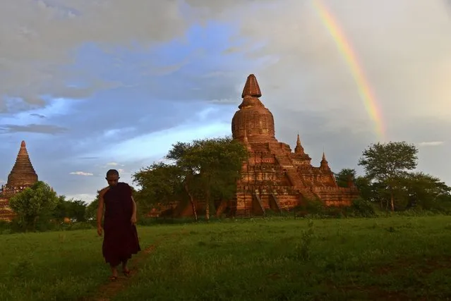 A monk walks through a field near a damaged temple (R) in Bagan, southwest of Mandalay, Myanmar, 24 August 2016. According to sources, a powerful 6.8 magnitude earthquake hit central Myanmar, causing two deaths and damage to several temples in the ancient city Bagan and some parts of central Myanmar. (Photo by Naing Tun Win/EPA)