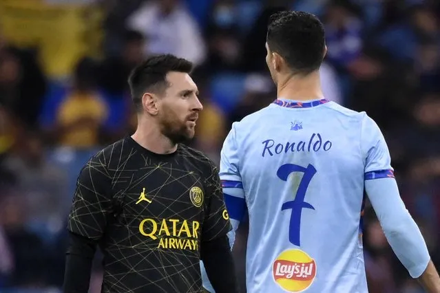 Paris Saint-Germain's Argentine forward Lionel Messi (L) walks past Riyadh All-Star's Portuguese forward Cristiano Ronaldo (R) during the Riyadh Season Cup football match between the Riyadh All-Stars and Paris Saint-Germain at the King Fahd Stadium in Riyadh on January 19, 2023. (Photo by Franck Fife/AFP Photo)