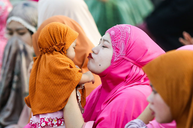 A mother kisses her daughter as they attend a prayer in celebration of the Eid al-Fitr in Quezon City, the Philippines, on April 10, 2024. (Photo by Xinhua News Agency/Rex Features/Shutterstock)