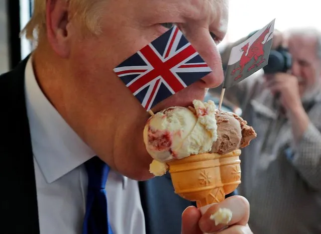 Boris Johnson, former U.K. foreign secretary, eats an ice cream cone as part of his Conservative Party leadership campaign tour, in Barry Island, U.K., on Saturday, July 6, 2019. Johnson, looking set for a landslide victory over rival Jeremy Hunt in the race to be Britain's next prime minister, has won the backing of a senior member of the cabinet: Home Secretary Sajid Javid. (Photo by Frank Augstein/Pool via Reuters)
