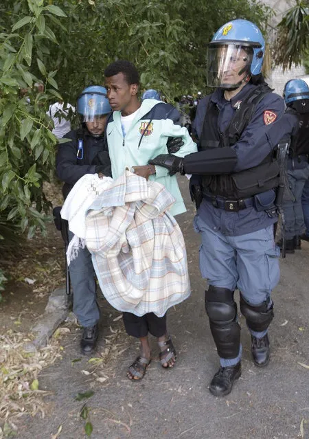 A migrant is evacuated by Italian police at the Franco-Italian border near Menton, southeastern France, Tuesday, June 16, 2015. Some 150 migrants, principally from Eritrea and Sudan, have been trying since last Friday to cross the border from Italy but have been blocked by French and Italian police. (AP Photo/Lionel Cironneau)