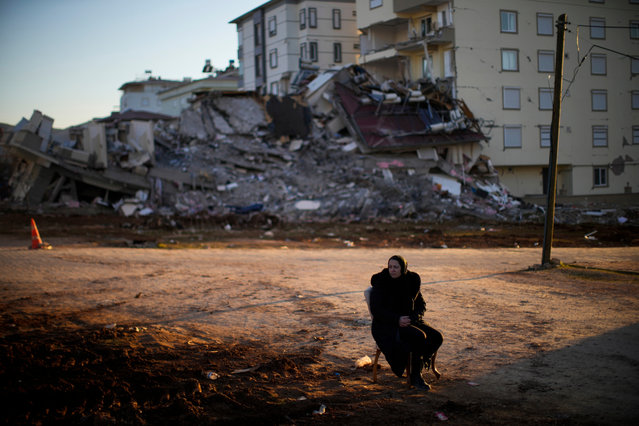 Fatos Baruc, who lives in Germany and whose mother-in-law survived the earthquake, sits on a chair as she waits for her belongings to take away from a damaged building in Pazarcik, Turkey, Monday, February 13, 2023. Thousands left homeless by a massive earthquake that struck Turkey and Syria a week ago packed into crowded tents or lined up in the streets for hot meals Monday, while the desperate search for anyone still alive likely entered its last hours. (Photo by Francisco Seco/AP Photo)