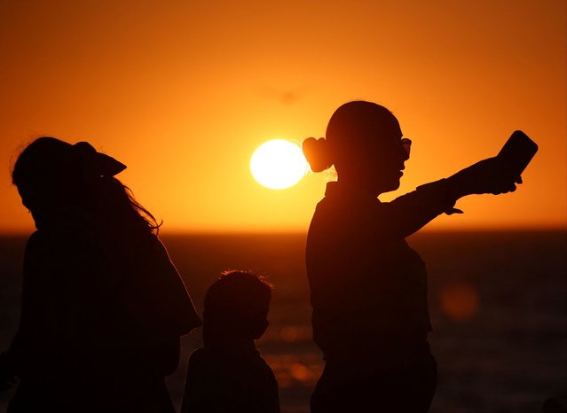 People are silhouetted at sunset as they visit the Malecon, one day ahead of a total solar eclipse in Mazatlan, Mexico April 7, 2024. (Photo by Henry Romero/Reuters)