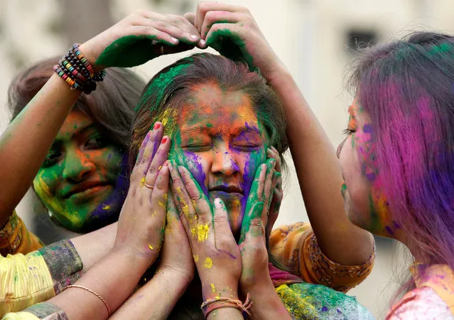 A college student reacts as others apply coloured powder on her face during Holi, the Festival of Colours, celebrations in Agartala, India March 10, 2017. (Photo by Jayanta Dey/Reuters)