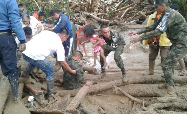 In this handout photo released by the Colombian National Army, soldiers rescue a child in Mocoa, Colombia, Saturday, April 1, 2017, after an avalanche of water from an overflowing river swept through the city as people slept. The incident triggered by intense rains left at least 100 people dead in Mocoa, located near Colombia's border with Ecuador. (Photo by Colombian Army Photo via AP Photo)