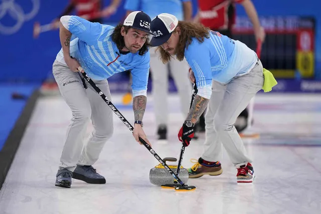 United States' Christopher Plys, left, and Matt Hamilton sweep the ice during the men's curling bronze medal match between Canada and the United States at the Beijing Winter Olympics Friday, February 18, 2022, in Beijing. (Photo by Brynn Anderson/AP Photo)
