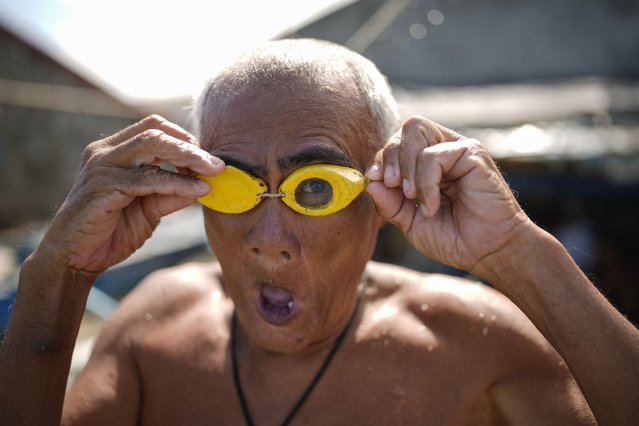 Jesus Culis adjusts his swimming goggles at the coastal village of Simlong in Batangas province, Philippines on Tuesday, August 8, 2023. He lost his vision on one eye during a childhood accident. (Photo by Aaron Favila/AP Photo)