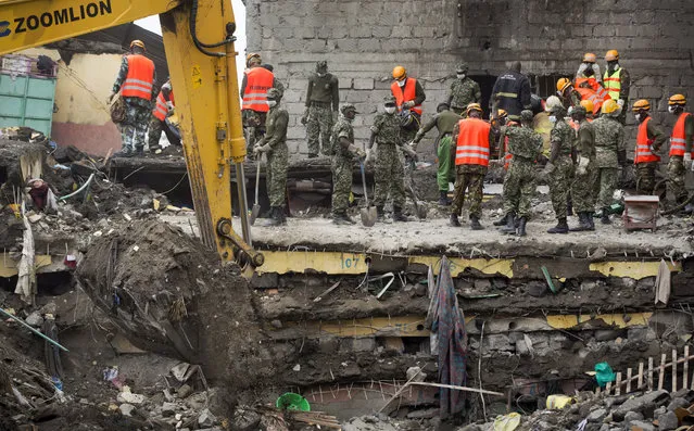 Rescuers standing on the sandwiched floors of the collapsed building continue the search for survivors and to retrieve more bodies, at the site of last week's building collapse in the Huruma neighborhood of Nairobi, Kenya Friday, May 6, 2016. (Photo by Ben Curtis/AP Photo)