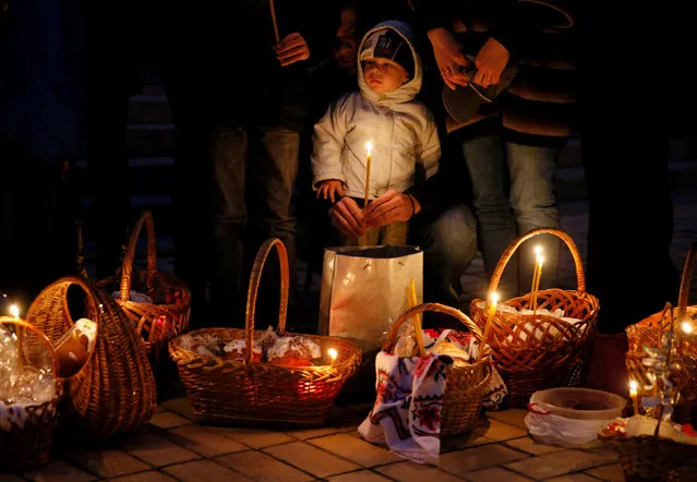 Believers wait for the beginning of the Orthodox Easter service outside the Mikhailovsky Zlatoverkhy Cathedral (St. Michael's Golden-Domed Cathedral) in Kiev, Ukraine, April 15, 2017. (Photo by Valentyn Ogirenko/Reuters)