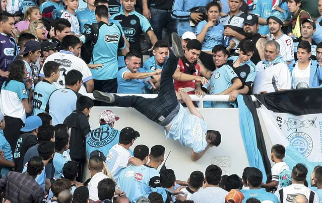 In this April 15, 2017 photo, Emanuel Balbo is thrown from the stands by other soccer fans during a match between Belgrano and Talleres, in Cordoba, Argentina. Balbo was declared brain dead after he was chased down the terraces of the stadium and thrown from the bleachers. Balbo's father said his son was attacked by a mob after he faced off with a man he blamed for killing his brother. (Photo by Alvaro Martin Corral/AP Photo)