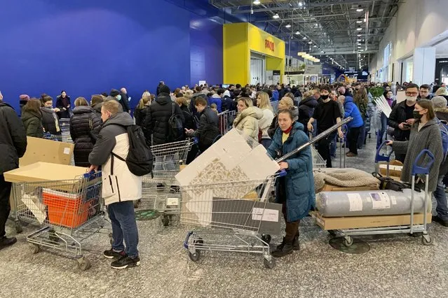 People wait in a line to pay for her purchases at the IKEA store on the outskirts of Moscow, Russia, Thursday, March 3, 2022. IKEA is closing its stores and pausing all sourcing in Russia and Belarus from Friday, March 4. “The conflict between Russia and Ukraine is a tragedy, and we deeply empathise with the millions of people affected by this situation” – IKEA's officials told. (Photo by Vladimir Kondrashov/AP Photo)