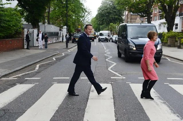 Prime Minister David Cameron with  former Culture Secretary Tessa Jowell try to recreate for the media  the famous Beatles album cover during their visit to Abbey Road recording studios in north London Friday May 20, 2016, where they met with representatives of the creative industries to discuss a letter that called for the Britain to remain in the EU. (Photo by Jeremy Selwyn/Pool, via AP Photo)