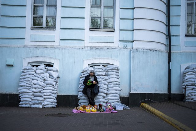 A woman sells toys in front of a building with windows protected by sandbags in Kyiv, Ukraine, Sunday, April 28, 2024. (Photo by Francisco Seco/AP Photo)