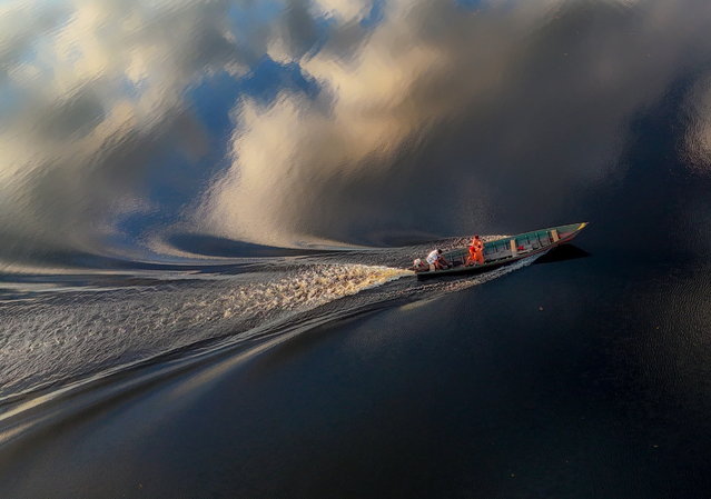 Aerial photograph showing a boat in the waters of the Urubu River, during sunset in the Brazilian Amazon region,  in Silves, Brazil, on 14 June 2024. (Photo by Antonio Lacerda/EPA)