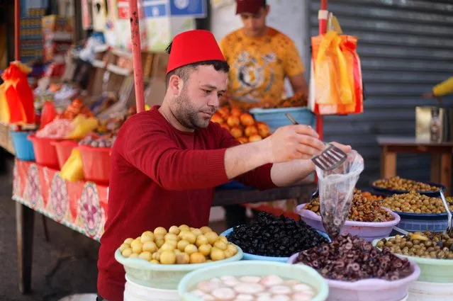 A Palestinian vendor sells olives and pickles in a market during the holy fasting month of Ramadan, amid a rise in prices as a result of the Russian invasion of Ukraine, in Khan Younis, in the southern Gaza Strip, April 4, 2022. (Photo by Ibraheem Abu Mustafa/Reuters)