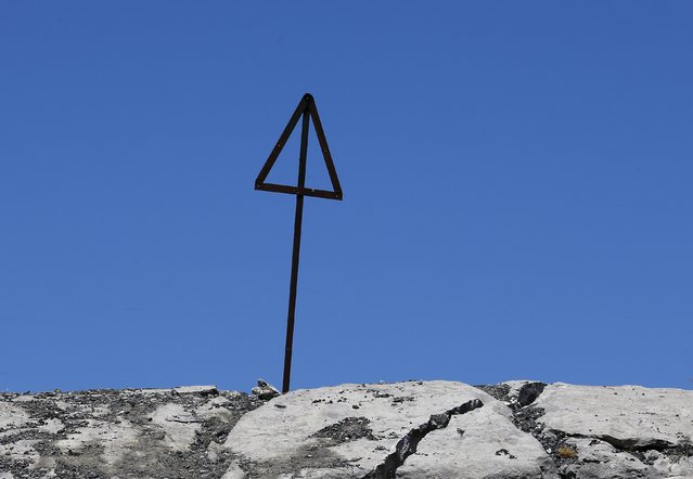 A road sign is seen on top of a rock in La Pierre Saint Martin during the 10th stage of the 102nd Tour de France cycling race from Tarbes to La Pierre-Saint-Martin, France, July 14, 2015. (Photo by Stefano Rellandini/Reuters)