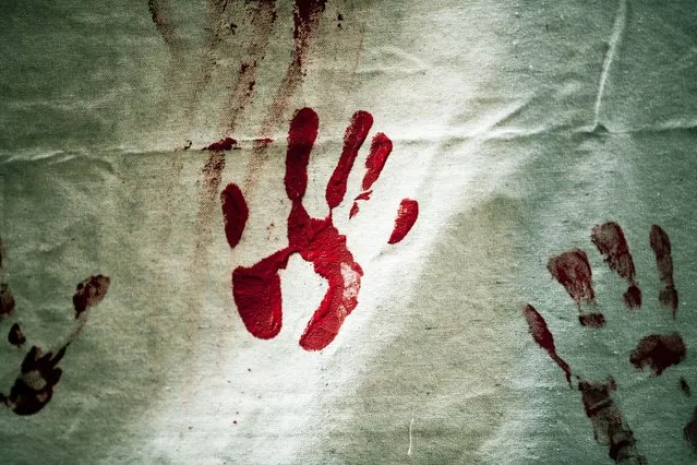 A protester leaves a red hand print on a canvas as hundreds of demonstrators gather to observe the anniversary of the Armenian Genocide, in front of the Turkish Consulate in Beverly Hills, California, USA, 24 April 2022. The demonstration took place on the 107th anniversary of the Armenian Genocide, under the slogan “Resist Genocide Denial Now”. (Photo by Etienne Laurent/EPA/EFE)