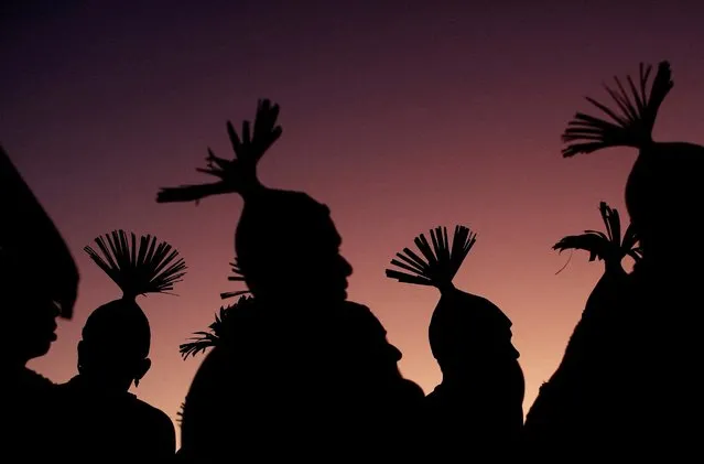 Indigenous people are silhouetted against the setting sun during a protest against Brazil's President Jair Bolsonaro and for land demarcation in Brasilia, Brazil, April 6, 2022. (Photo by Adriano Machado/Reuters)