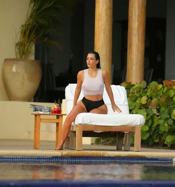 Kim Kardashian looks stunning in a see-through white tank top as she enjoys a second honeymoon in Mexico with Kanye West. The newly-weds stayed at the exclusive home of Girls Gone Wild founder Joe Francis, after jetting in to Punta Mita, to catch some pool side relaxation. The Wests honeymooned in Ireland and Prague after their May 24 wedding in Italy. (Photo by Brian Prahl/Splash News)