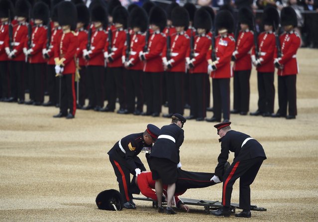 A Guardsman faints at Horseguards Parade for the annual Trooping the Colour ceremony in central London, Britain June 11, 2016. (Photo by Dylan Martinez/Reuters)